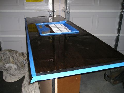 1996 Ford Bronco - A workbench is prepared for finishing, with blue tape outlining the surface and a tray with a grid on top.