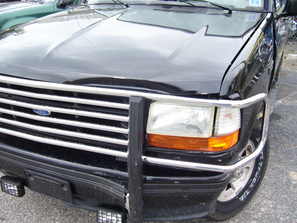 Black Ford truck front with chrome grille guard and rectangular headlight