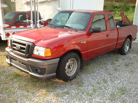 1999 Ford Ranger - A red Ford Ranger pickup truck is parked on a gravel lot, with a trailer reflecting another vehicle.