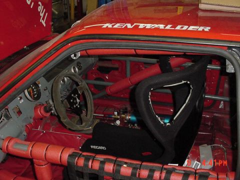 1993 Ford Mustang - Interior view of a modified red car with racing modifications and visible text on the exterior.