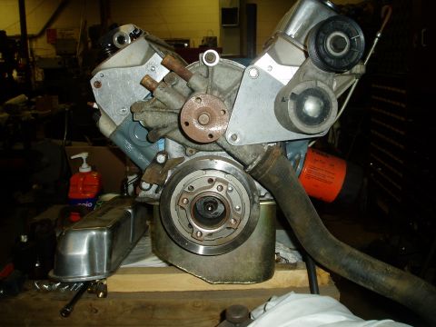 1978 Ford F-250 - This V8 engine assembly features a water pump, belt pulley, and an orange oil filter. A chrome valve cover is also present.