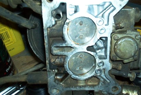 1986 Ford Bronco - This is a close-up view of a vehicle's carburetor, revealing its internal components and passages.