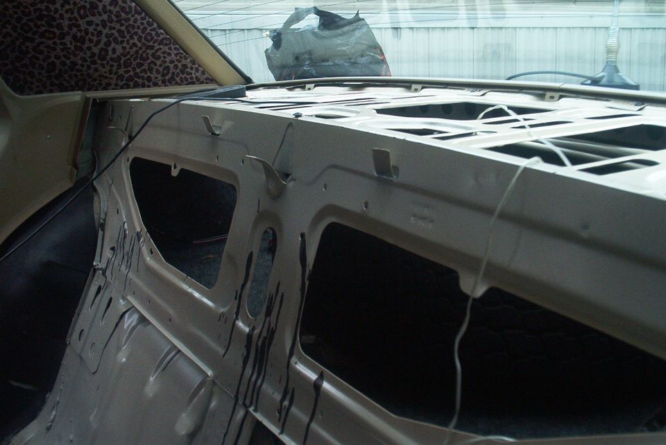 Car interior stripped down, showing metal frame and leopard print headliner