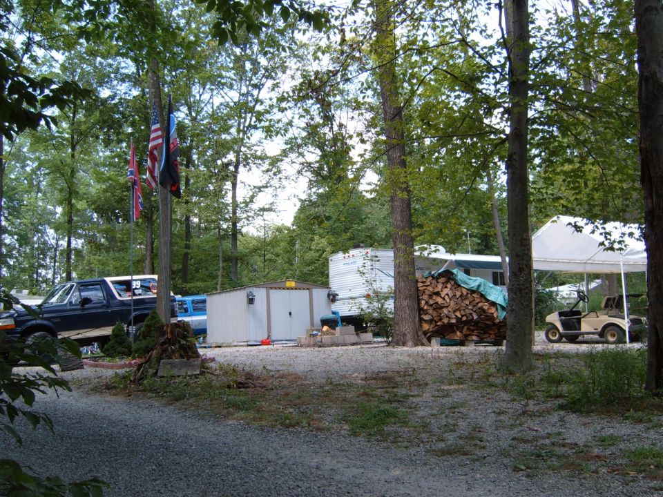 Dark blue Ford Bronco with white top, parked on gravel