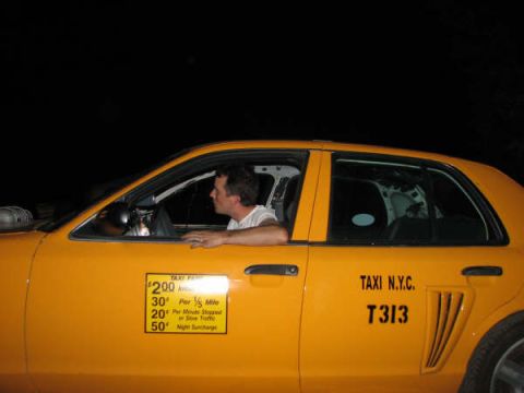 2001 Mercury Grand Marquis - A driver sits in a yellow taxi cab, with fare information visible on the door.