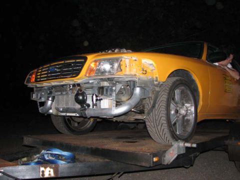 2001 Mercury Grand Marquis - A yellow 2001 Mercury Grand Marquis is seen from the front with its bumper and grille removed, revealing custom turbocharger and intercoole…