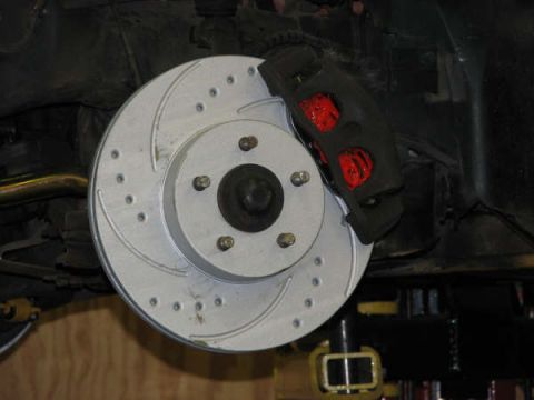 2001 Mercury Grand Marquis - A drilled brake rotor and caliper are visible on a vehicle's suspension system.
