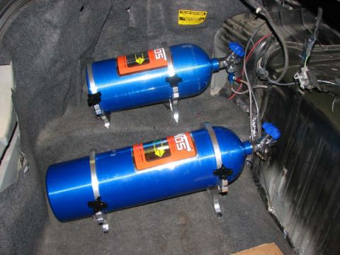 2001 Mercury Grand Marquis - Trunk installation of dual nitrous oxide bottles, each with a blue valve and mounting brackets.