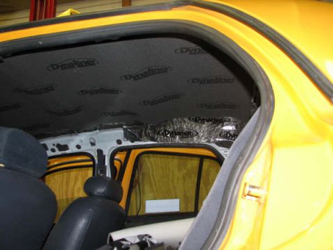 2001 Mercury Grand Marquis - Sound deadening material is being installed on the interior ceiling of a yellow vehicle.