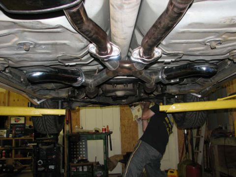 2001 Mercury Grand Marquis - A mechanic works on the undercarriage of a vehicle, focusing on the exhaust system.