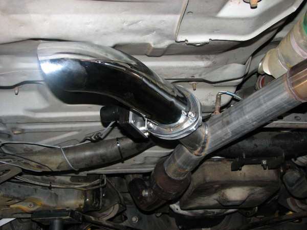 Underside view of a vehicle's exhaust system, showing pipes and a chrome tip