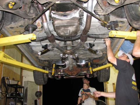 2001 Mercury Grand Marquis - Car is on a lift, showing the underside and exhaust system with people around.