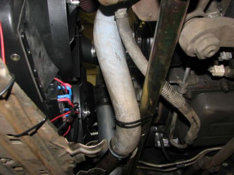 2001 Mercury Grand Marquis - Close-up view of engine bay components, including hoses, wiring, and a fan, with visible signs of wear.
