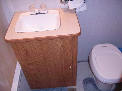 1993 Ford Bronco - Interior view of a small RV bathroom with a sink and toilet.