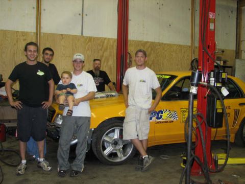 2001 Mercury Grand Marquis - A group of people stand with a yellow 2001 Mercury Grand Marquis taxi in a garage.