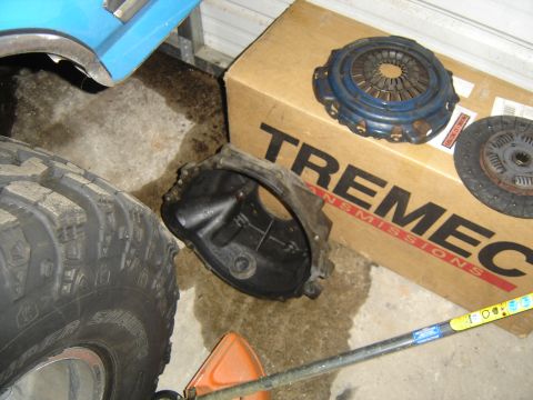 1988 Ford Bronco - Clutch and bell housing parts are laid out on the floor next to a TREMEC transmissions box.