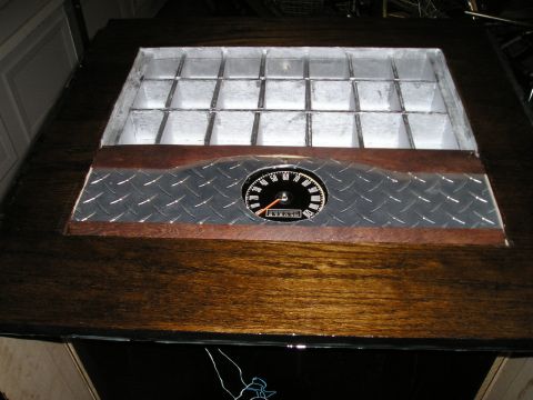 1996 Ford Bronco - A gauge cluster with an odometer is mounted on a surface diamond plate and wood grain.