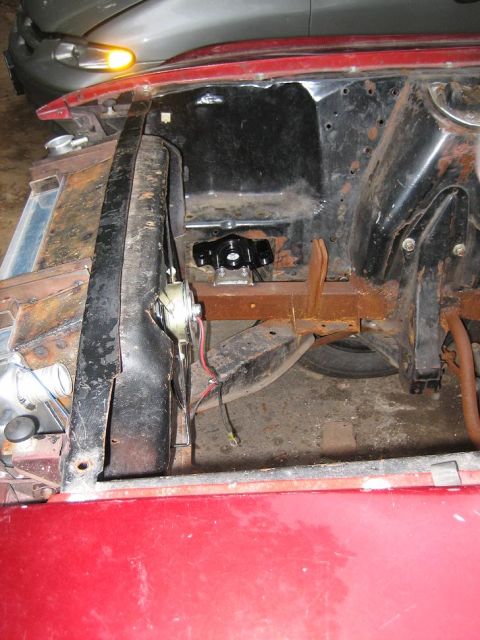 1969 Ford Mustang - The engine bay of a 1969 Ford Mustang shows a red exterior and an aftermarket black component installed.