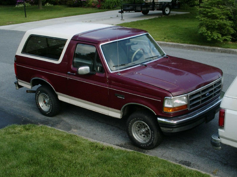 Maroon and white 1992 Ford Bronco parked on a street, viewed from the front-right