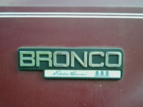 1992 Ford Bronco - Close-up of a Bronco Eddie Bauer emblem on a maroon vehicle.