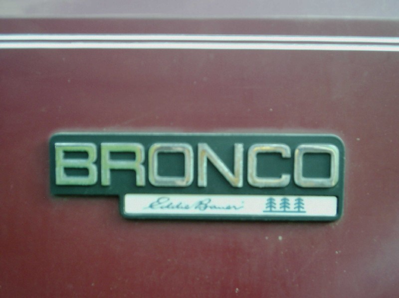 Chrome BRONCO fender badge with Eddie Bauer script on a maroon body panel