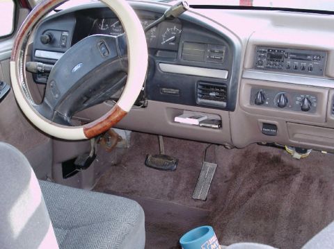 1992 Ford Bronco - The interior of a vehicle, the dashboard, steering wheel, and pedals. A watermark indicates the source of the image.