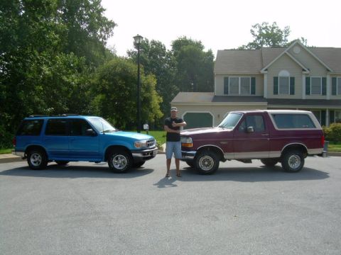 1992 Ford Bronco - A man stands between a maroon 1992 Ford Bronco and a blue SUV in a driveway.