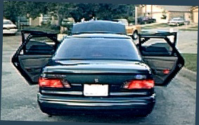 1994 Ford Taurus - Rear view of a 1994 Ford Taurus, all doors open, with a roof-mounted carrier.