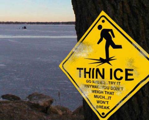 1992 Ford Taurus - A sign warns of thin ice on a frozen body of water, with two distant figures on the ice.