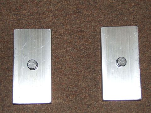 1988 Ford Bronco - Two metal plates with bolts are shown on a carpeted surface.