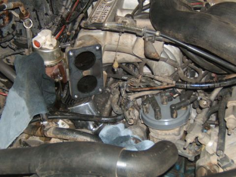 1988 Ford Bronco - Close-up of an engine bay, with the throttle body removed, revealing internal components and wiring.