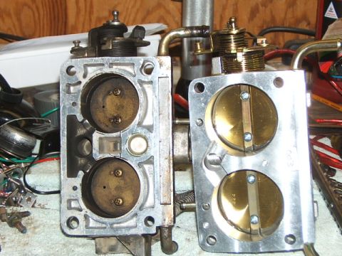 1988 Ford Bronco - Close-up view of two automotive throttle bodies, one showing wear and the other appearing new or recently cleaned.