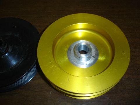 1996 Ford Bronco - Two automotive pulleys are shown, one with a yellow finish and the other black.