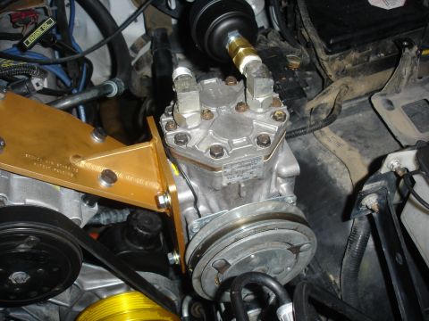 1996 Ford Bronco - Close-up view of a vehicle's air conditioning compressor and associated plumbing.