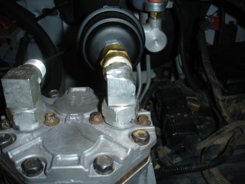 1996 Ford Bronco - Close-up view of an engine component with various metal connections and a filter.