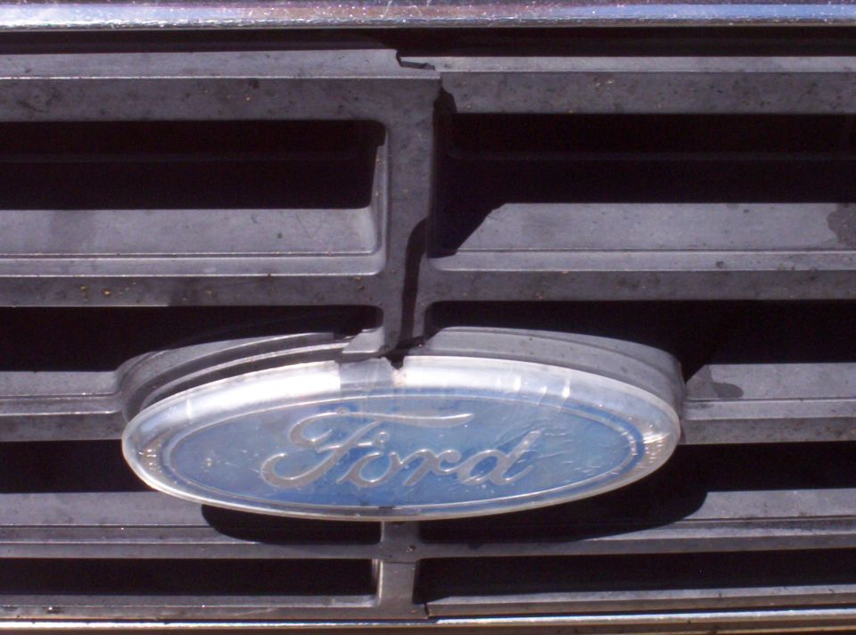 Oval blue Ford emblem badge mounted in a weathered chrome truck grille
