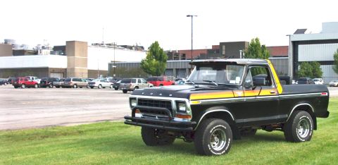 1979 Ford Bronco - This black 1979 Ford Bronco features distinctive yellow and orange side stripes and a brush guard on the front bumper.