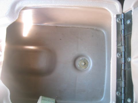1996 Ford Bronco - This image shows the interior of a vehicle's storage compartment, including a metal hinge on the right side.