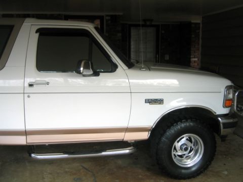 1996 Ford Bronco - This 1996 Ford Bronco is shown from the front three-quarter angle, highlighting its side steps and the prominent 'BRONCO' badge on the fend…