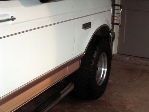 1996 Ford Bronco - Close-up of the side of a 1996 Ford Bronco, highlighting the fender and wheel.