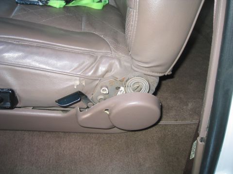 1996 Ford Bronco - Close-up of a worn car seat mechanism, revealing springs and adjustment levers.