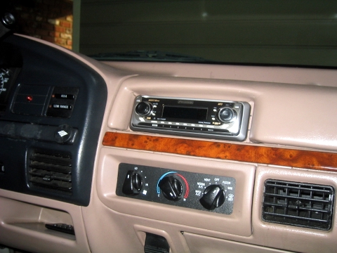 1996 Ford Bronco - The interior dashboard features an aftermarket radio, climate controls, and wood grain trim.