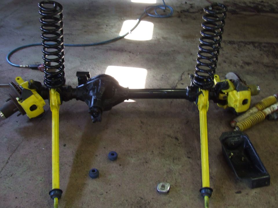Front axle assembly with yellow control arms and black springs
