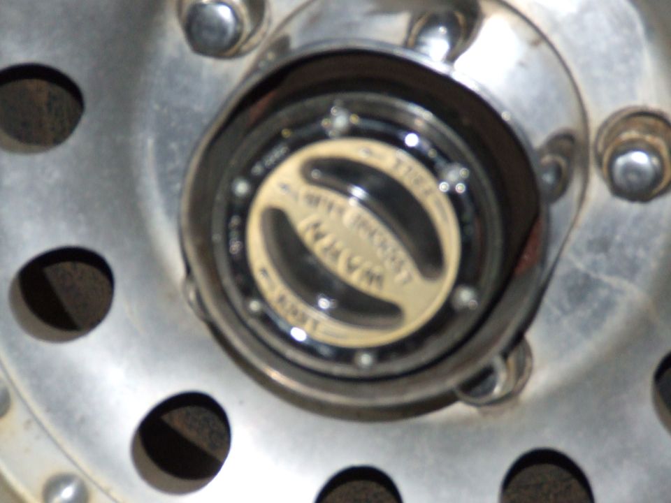 Close-up of a metal hubcap with a yellow and black "WARNER" logo