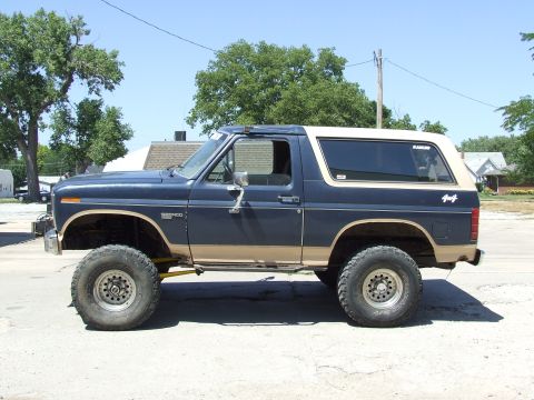 1986 Ford Bronco - This lifted Ford Bronco displays a two-tone paint scheme and prominent "4x4" badging on the rear quarter panel.