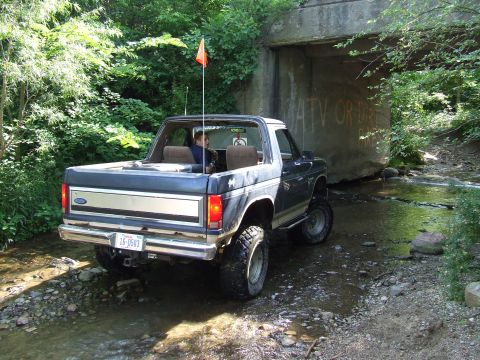 1986 Ford Bronco - This 1986 Ford Bronco is navigating a rocky stream bed beneath an overpass with graffiti.