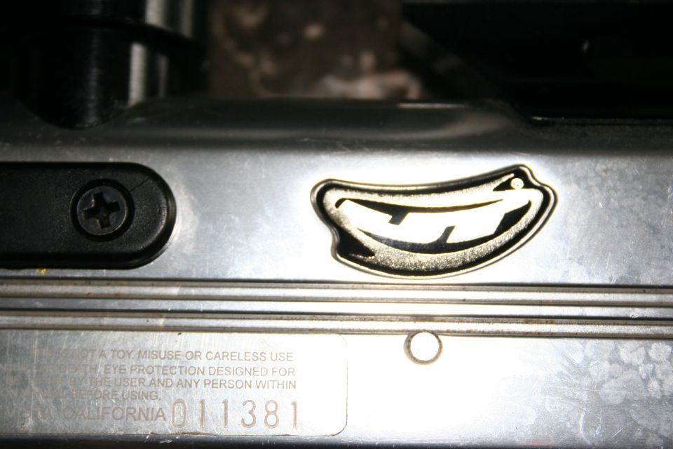Close-up of a metal part with a stylized banana logo and 'CALIFORNIA 011381' stamped on it