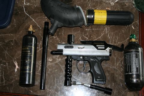 2004 Jeep TJ - A disassembled paintball gun with two CO2 tanks and a barrel are laid out on a marble surface.