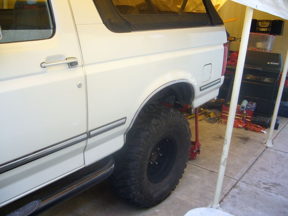 White 1992 Ford Bronco rear quarter panel with large off-road tires