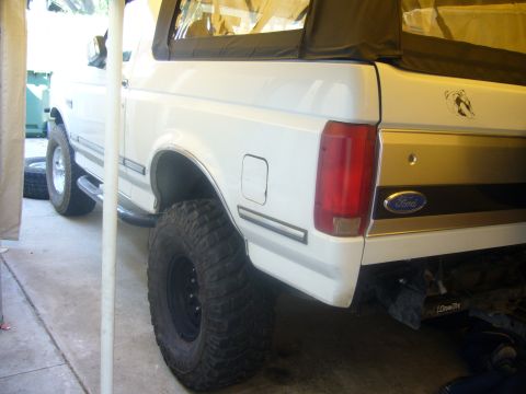 1992 Ford Bronco - Rear view of a white 1992 Ford Bronco, modified with large off-road tires.
